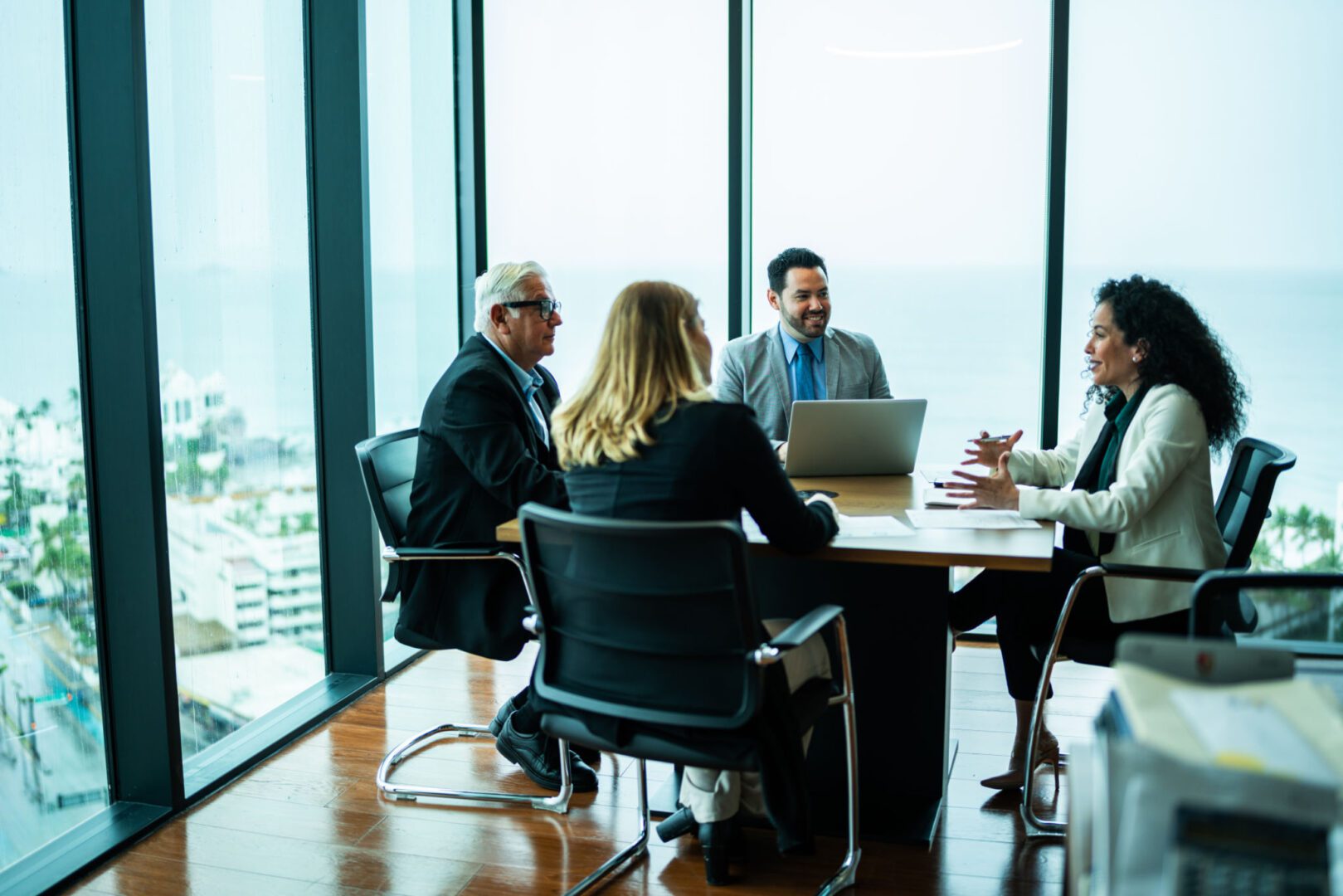 Business meeting in modern glass-walled office.