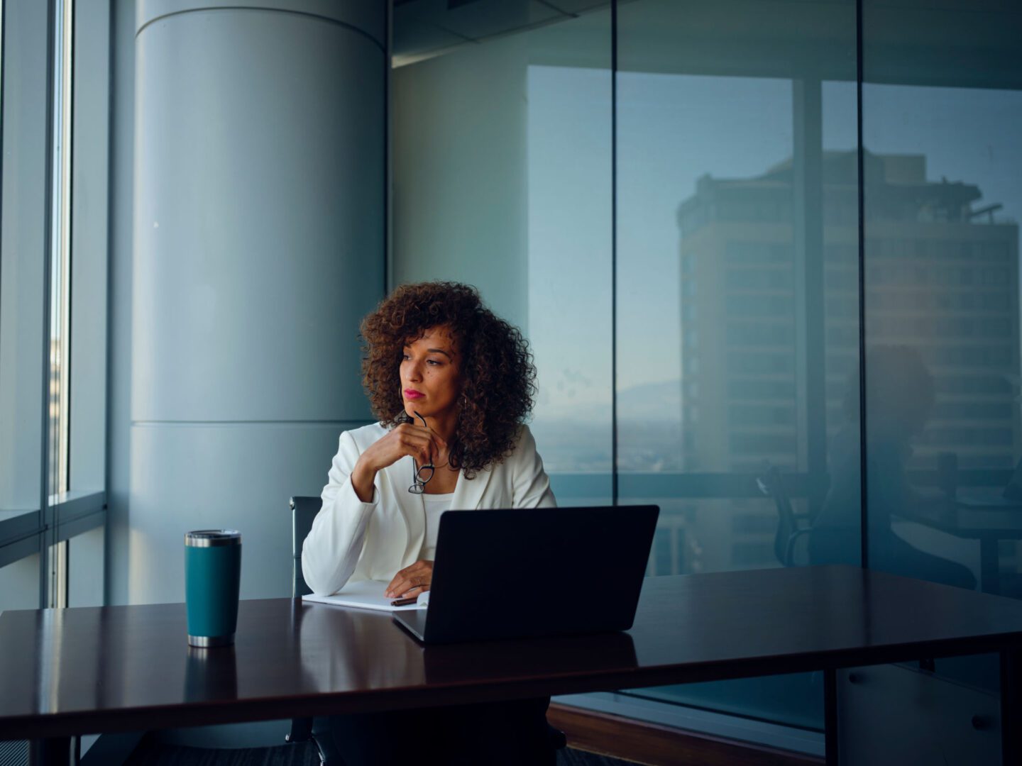 Woman working at a laptop in office.