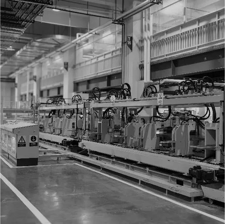 Black and white image of a car manufacturing assembly line.